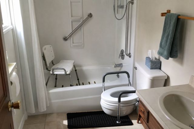 bathroom: Dark bath mat on a light floor